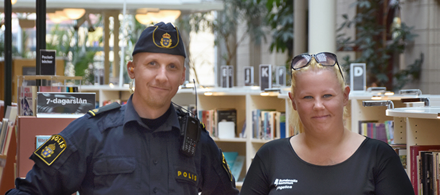 Foto. Två personer står framför bokhyllor på Sundsvalls stadsbibliotek.