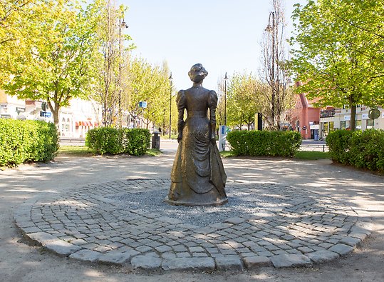 Skulptur i helfigur på feministen och författaren Frida Stéenhoff, Esplanaden vid Sundsvalls teater.