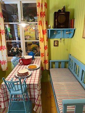 Köksbord och soffa i upplevelserummet Pettson och Findus, mucklor och manicker.