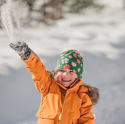 Barn kastar upp snö i luften. Foto: Sundsvalls kommun.
